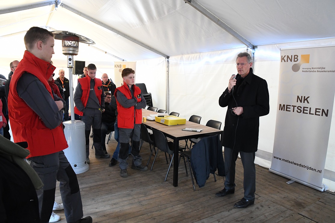 KNB-directeur Ewald van Hal spreekt de jongens bemoedigende woorden toe en benadrukt het belang van het NK Metselen